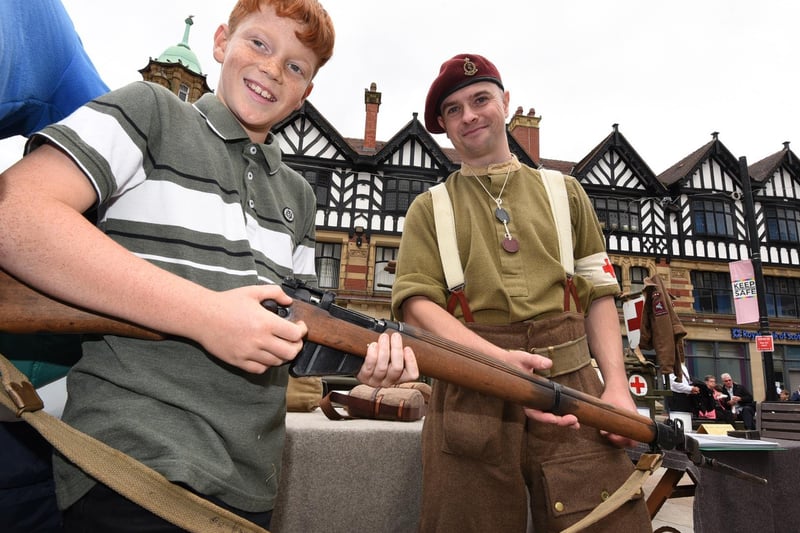 Jamie Cameron, right, shows Lewis Vaughan, 11, vintage weapons.