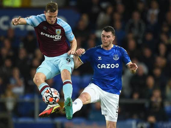Chris Wood challenges with former Claret Michael Keane