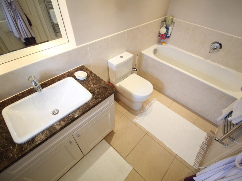 A modern bathroom suite includes a basin with a vanity unit surround.