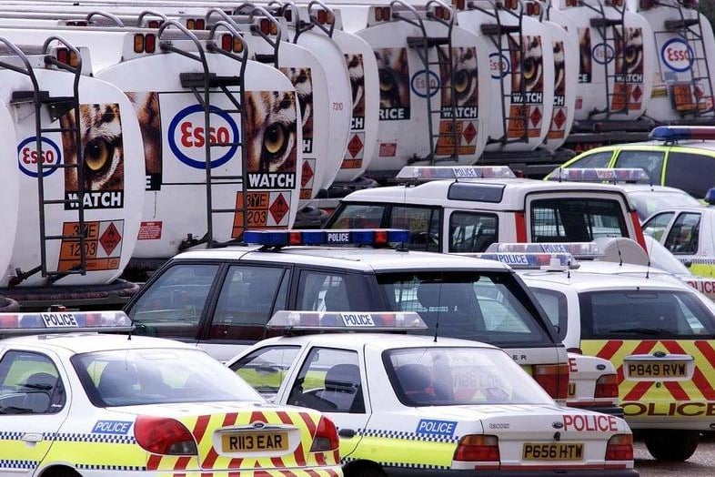 Police cars get ready to escort petrol tankers out of the oil refinery at Purfleet in Essex.