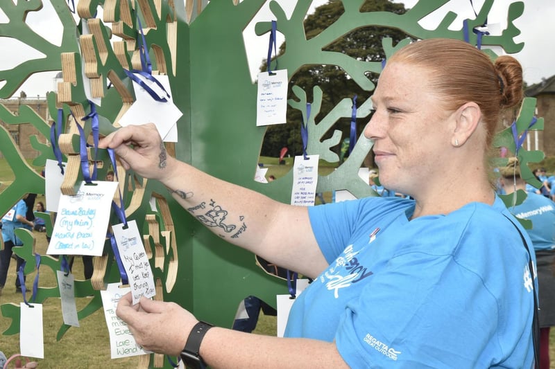 Emma Whitemen of Seacroft places a card on the Memory Tree for her nana Muriel