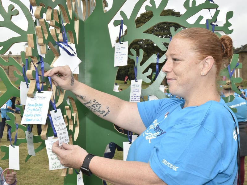 Emma Whitemen of Seacroft places a card on the Memory Tree for her nana Muriel