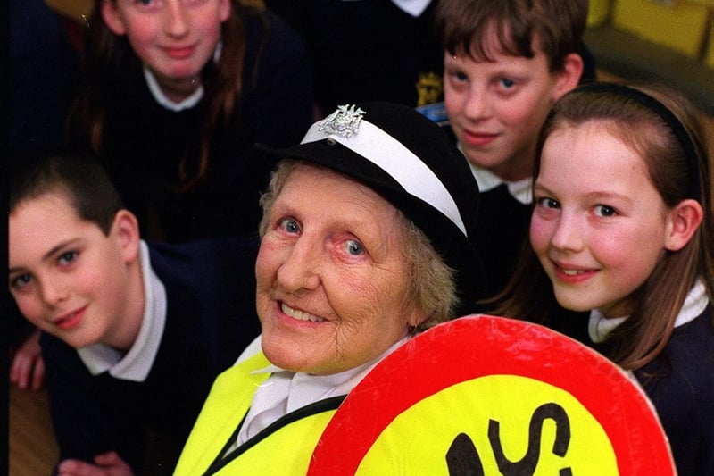 This is lollipop lady Kath Stone who retired after 32 years in March 1999. She is pictured with some of the pupils at Victoria Junior and Infant School in Morley.