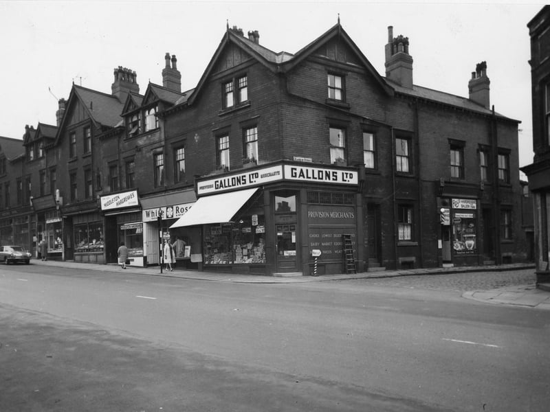 A parade of shops on Beeston Road at the junction with Marquis Street in July 1964. On the corner of Marquis Street is Gallons Ltd Provision Merchants where advertised in the windows are pork luncheon, eat at 1/9, fruit salad 1/4 and fresh butter at 2/3 a pound.