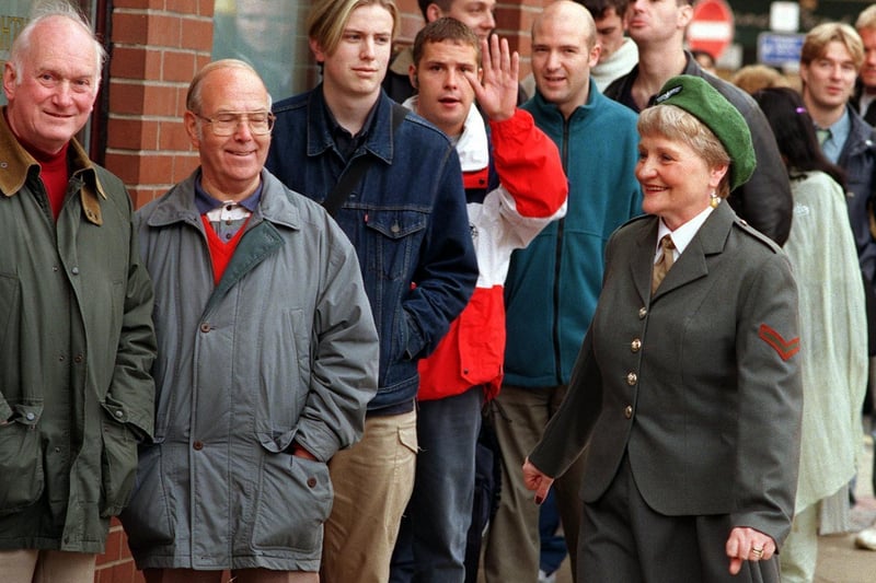 Frank Bird Menswear in Wakefield was selling its front window clothes at 1939 prices in October 1999. Early birds queue outside the shop marshalled by Joanne Bird company secretary in her WRAF war time uniform.