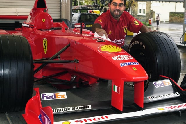 Garage owner Raj Patel polishes a replica of Schumacher's Formula 1 Ferrari at Morley Service Station in November 2002.