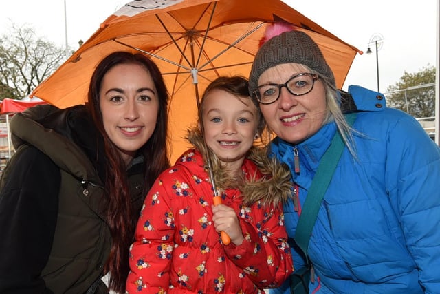 Laura Dickinson, left, Gill Dickinson, right, with grandaughter Nola, seven, brave the rain to watch the bands