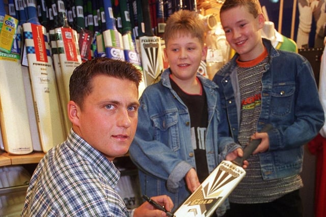 England and Yorkshire cricket star, Darren Gough, signs autographs for fans in October 1996. He is pictured with young Garforth Cricket Club players, Daniel Mann (left) and James Fender.