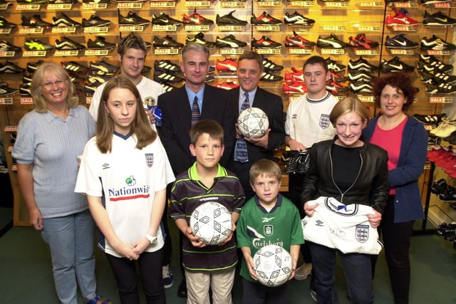 Lillywhites manager Bruce Milton presents competition winners with their prizes in July 2000.