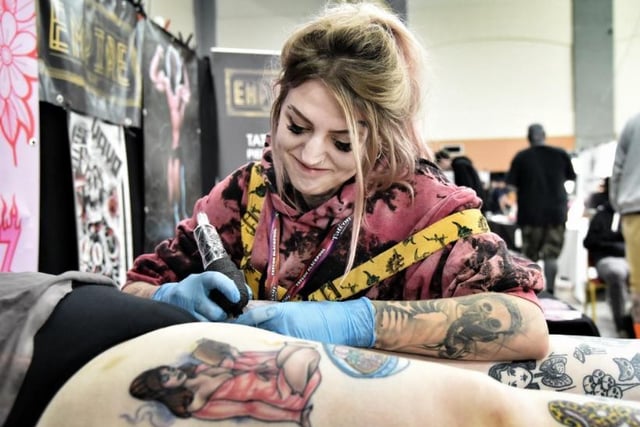 Tattooist Chloe Farrell adds to a customer's vast array of body art