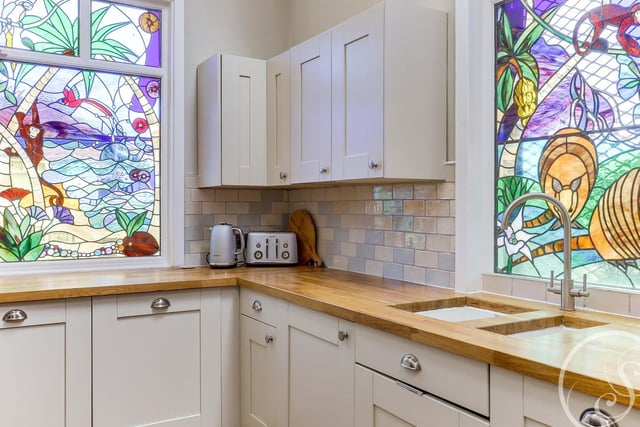 The stained glass windows are a special highlight of this house, featuring a tropical, jungle design and allowing plenty of colours into the room.
