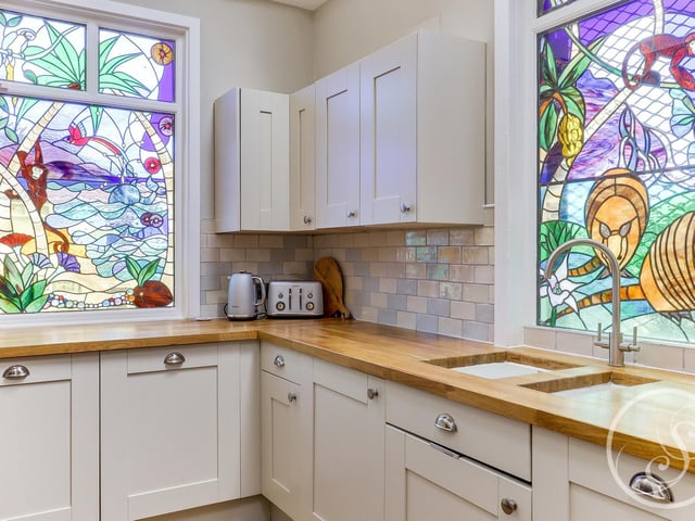 The stained glass windows are a special highlight of this house, featuring a tropical, jungle design and allowing plenty of colours into the room.