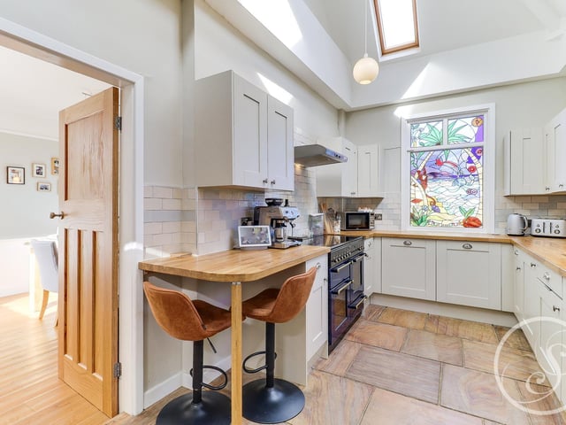 The modern kitchen has a range of modern fitted wall and base units, one and a half bowl ceramic sink. Range cooker with an extractor hood over. Integrated washing machine, fridge/freezer and dishwasher.