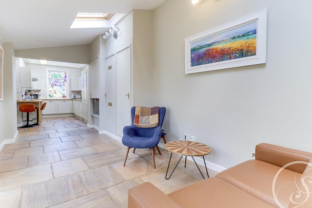 It also leads into a snug family area with a sofa and chair. The room benefits from  underfloor heating, additional storage cupboards and double glazed folding doors leading onto the garden.