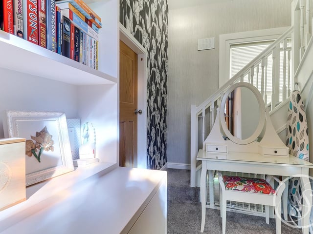 At the first floor level is a study area with fitted bookshelves, storage cupboard and stairs leading to the second floor.