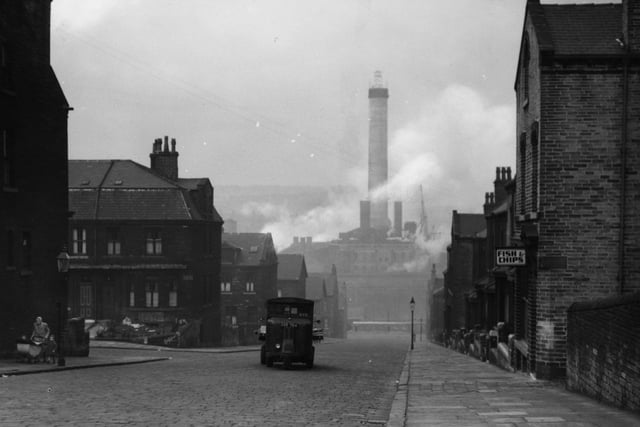 A van making its way down a street in an industrial area of Bradford, circa 1940.