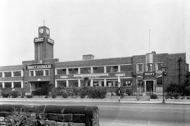 Thrift Stores on Bridge Road pictured in June 1949, showing clock tower. Banners on front of building advertising Electrical Washer Demonstrations Daily. Car parked in front. The building later became Clover Stores then Allders, then a BHS store.