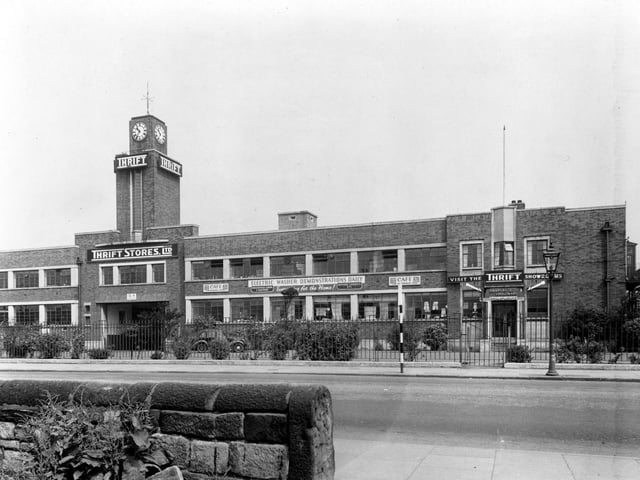 Thrift Stores on Bridge Road pictured in June 1949, showing clock tower. Banners on front of building advertising Electrical Washer Demonstrations Daily. Car parked in front. The building later became Clover Stores then Allders, then a BHS store.
