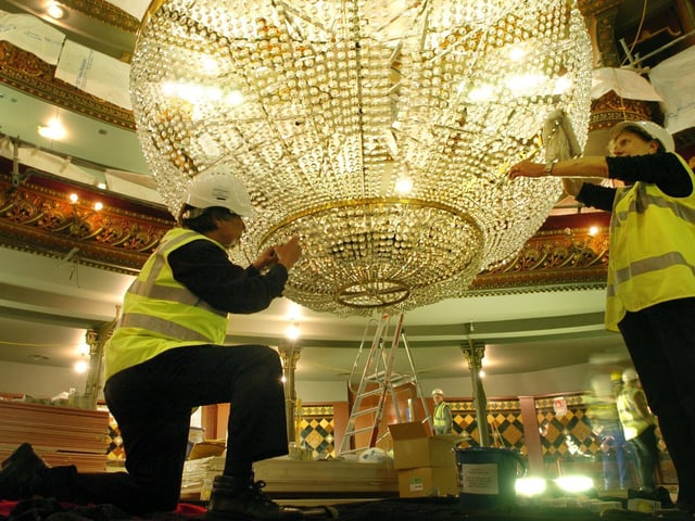 Michael Wilks, left, and Sheila Coates help clean the huge chandelier at the Leeds Grand as part of the theatre's refurbishment in June 2006.