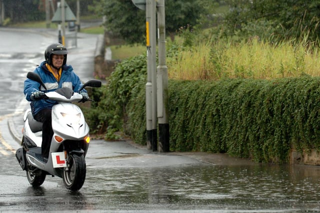 Heavy rain brought chaos to Leeds in August 2006. A motorcyclist goes round flood water on Wood Lane in Rothwell.