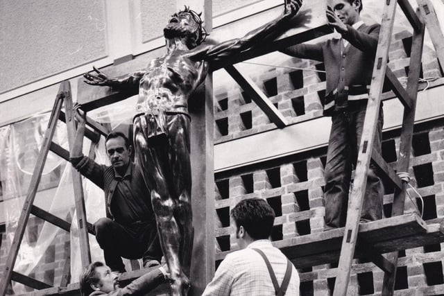 Sculptor and senior lecturer Charles Panson helps workmen put up his Crucifixtion figure at Trinity & All Saints College in Horsforth in October 1971. He took 18 months to complete the bronze and glass fibre work.