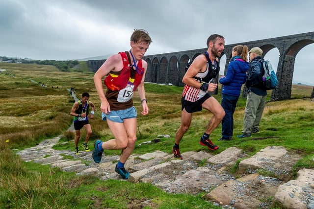 Runners make their way alongside Ribblehead viaduct and onwards towards the summit of Whernside.