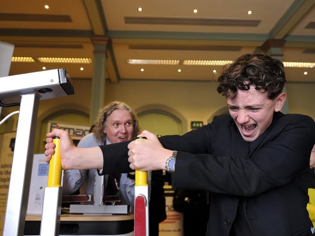 Graham School's Tim Hutchinson is amazed as Charlie takes a go on the strength test machine on Plaxton's stand.