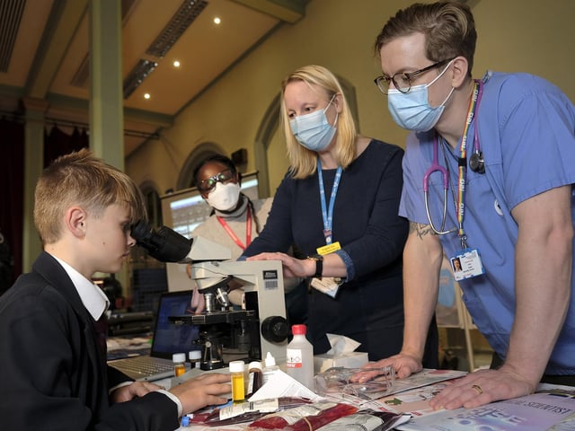 Graham School's Finley with NHS staff Yeukai Chibanguza, Angela Too and John Artley explaining medical facts.