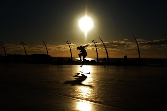 A skateboarder at sunset on the Comedy Carpet