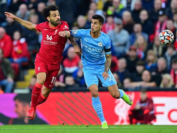 Liverpool's Egyptian midfielder Mohamed Salah (L) challenges Manchester City's Spanish midfielder Rodrigo during the English Premier League football match between Liverpool and Manchester City at Anfield in Liverpool, northwest England, on October 3, 2021.