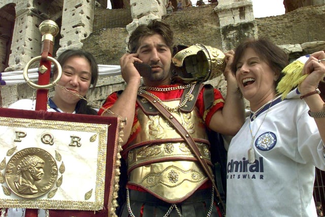 Leeds United fans enjoy themselves in Rome at the Colosseum. Pictured are Lai-Yim-Lam and Chrissie Coleman with a Roman soldier on his mobile phone.