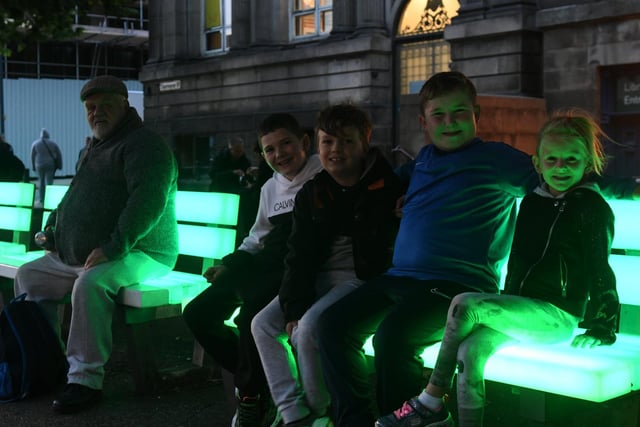 Youngsters sitting on one of the  'Light Benches' outside Leeds City Library.