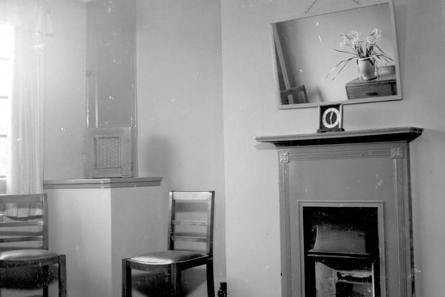 A furnished living room with fireplace pictured in March 1938.