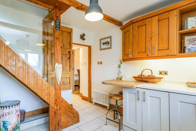 The fitted, country style kitchen has a side staircase to the first floor.
