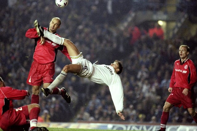 Alan Smith scores with a spectacular overhead kick despite the attentions of Lokomotiv defender Oleg Pachinine.