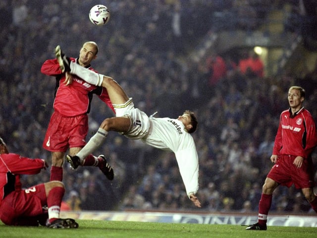 Alan Smith scores with a spectacular overhead kick despite the attentions of Lokomotiv defender Oleg Pachinine.