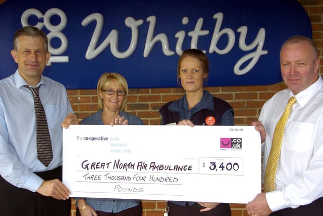 Staff at Whitby Co-op present a cheque to the Great North Air Ambulance.