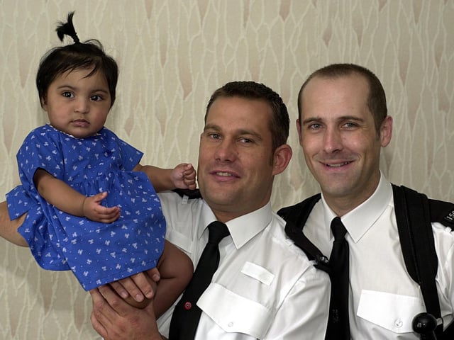 PC Neil Bottomley, left, and PC Paul Morris are pictured with seven month old Aishah Hussain who they rescued from a house fire in Beeston.