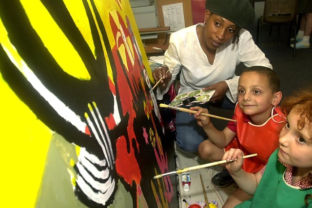 Artist Marcia Brown helps Beeston Primary School pupils Harry Loucas and Georgina Brayshaw with a painting the children were producing in July 2003.