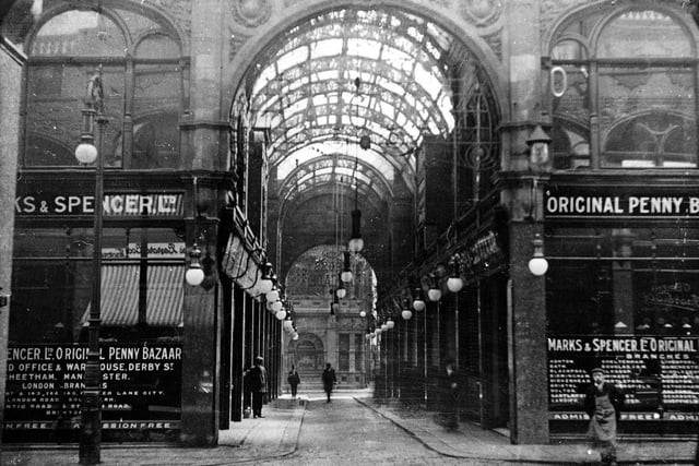 A view down Cross Arcade showing, elaborate roof and street lights, with Marks & Spencer on either side. This photograph shows the first shop occupied by the 'Original Penny Bazaar' out-side the market, where it operated from 1904.