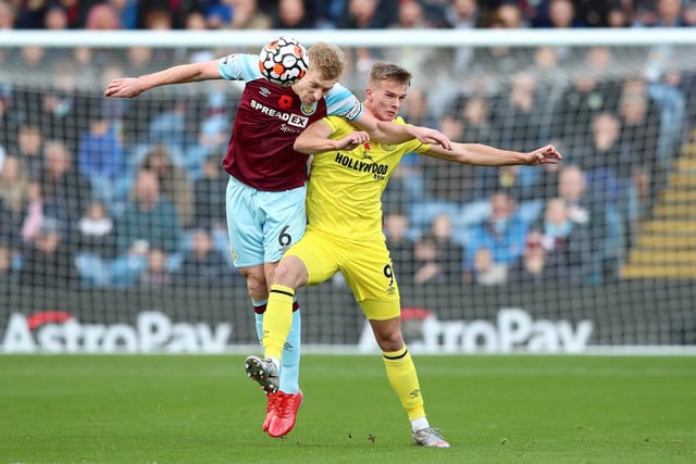 Ben Mee of Burnley battles for possession with Marcus Forss of Brentford during the Premier League match between Burnley and Brentford at Turf Moor on October 30, 2021 in Burnley, England.