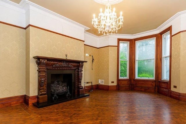 A large bay window and a carved feature fireplace give character to this room.