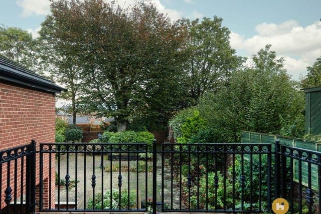 A patio area with railings looks over part of the garden