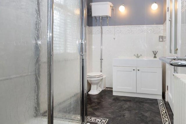 A white suite including a basin with vanity unit, and a shower cubicle within the property.