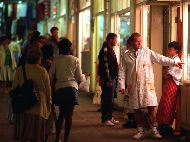A butcher tries to attract customers to his shop in July 1996.