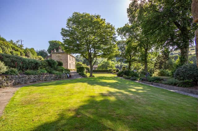 The property stands within extensive grounds, with lawned gardens.