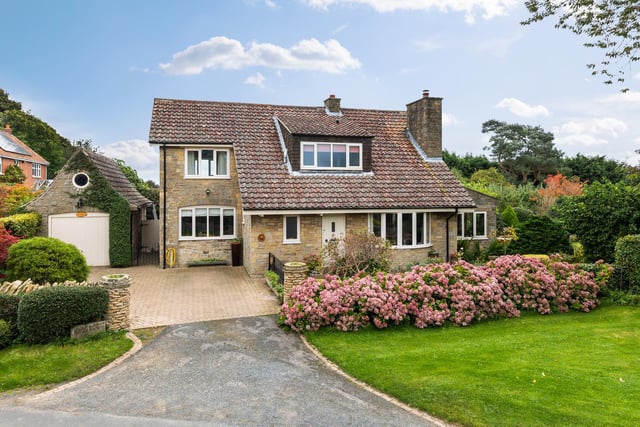The detached house has an attractive frontage, with a garage to the side