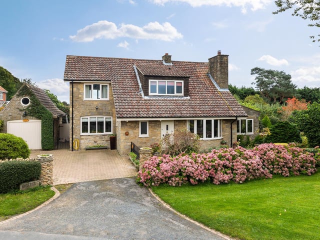 The detached house has an attractive frontage, with a garage to the side