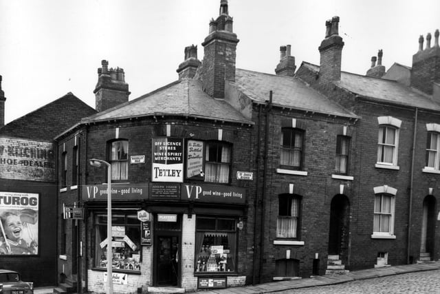 Woodsley Road in November 1963 with an off licence owned by Joseph Fisher in view. There are advertisements outside the shop for Tetleys beer and VP wine. In the window Moorhouses Xmas Puddings are on sale for 2/11d (just less than 15p).