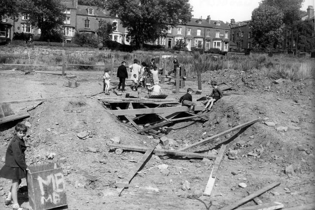 Children make use of a makeshift adventure playground on an area of wasteland off Woodsley Road in August 1969. A girl holds a tea chest in the bottom left of this photo.